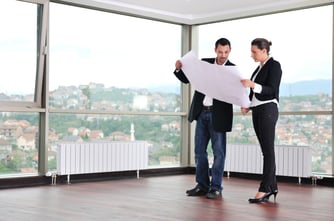 young architect group in big bright modern new apartment looking blueprints and building plans.jpeg