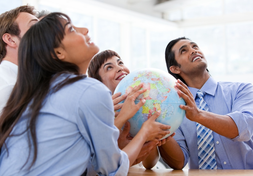 International business team holding a terrestrial globe in a meeting.jpeg