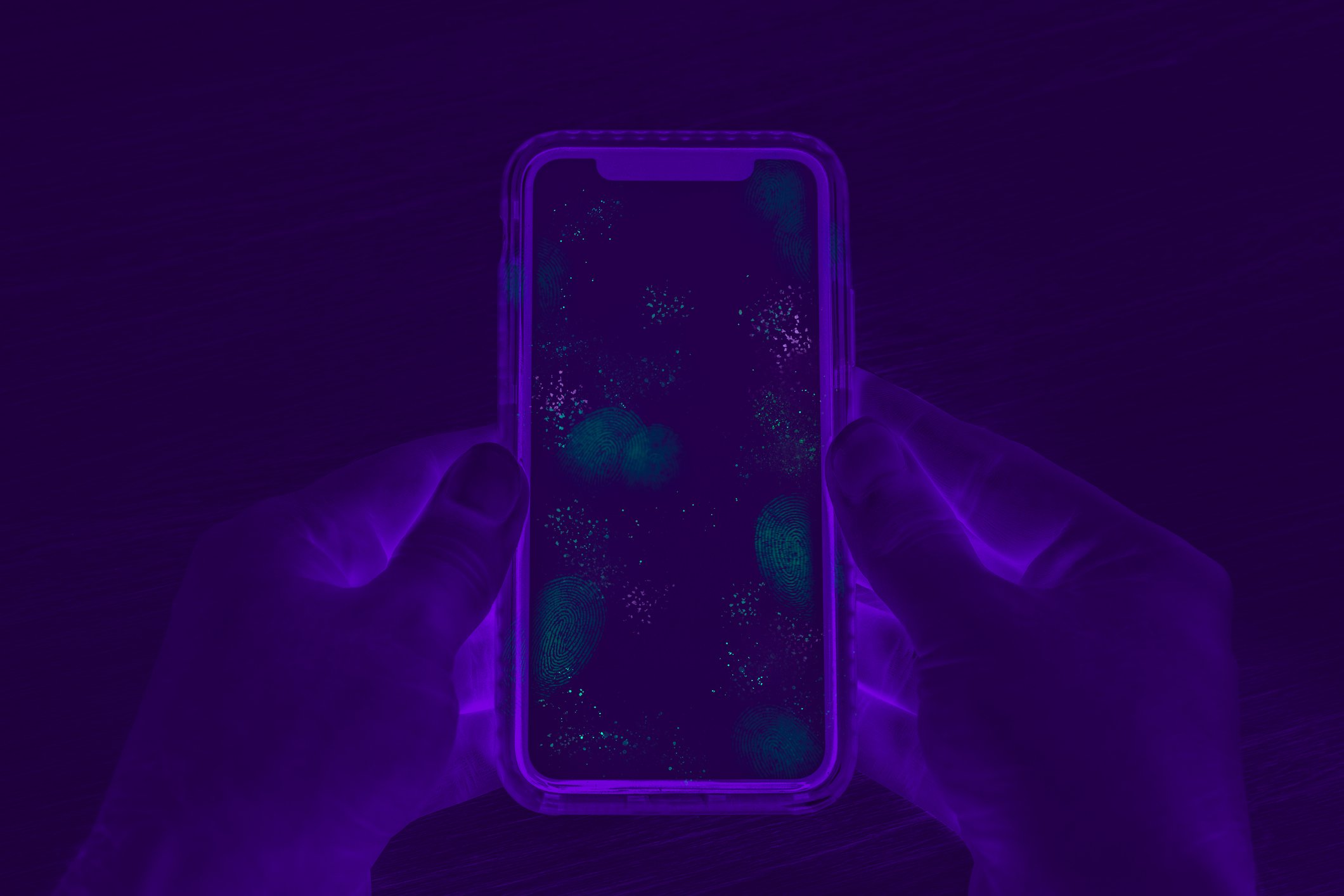 Invisible germs and bacteria on smartphone screen exposed by UV Blacklight inspection stock photo