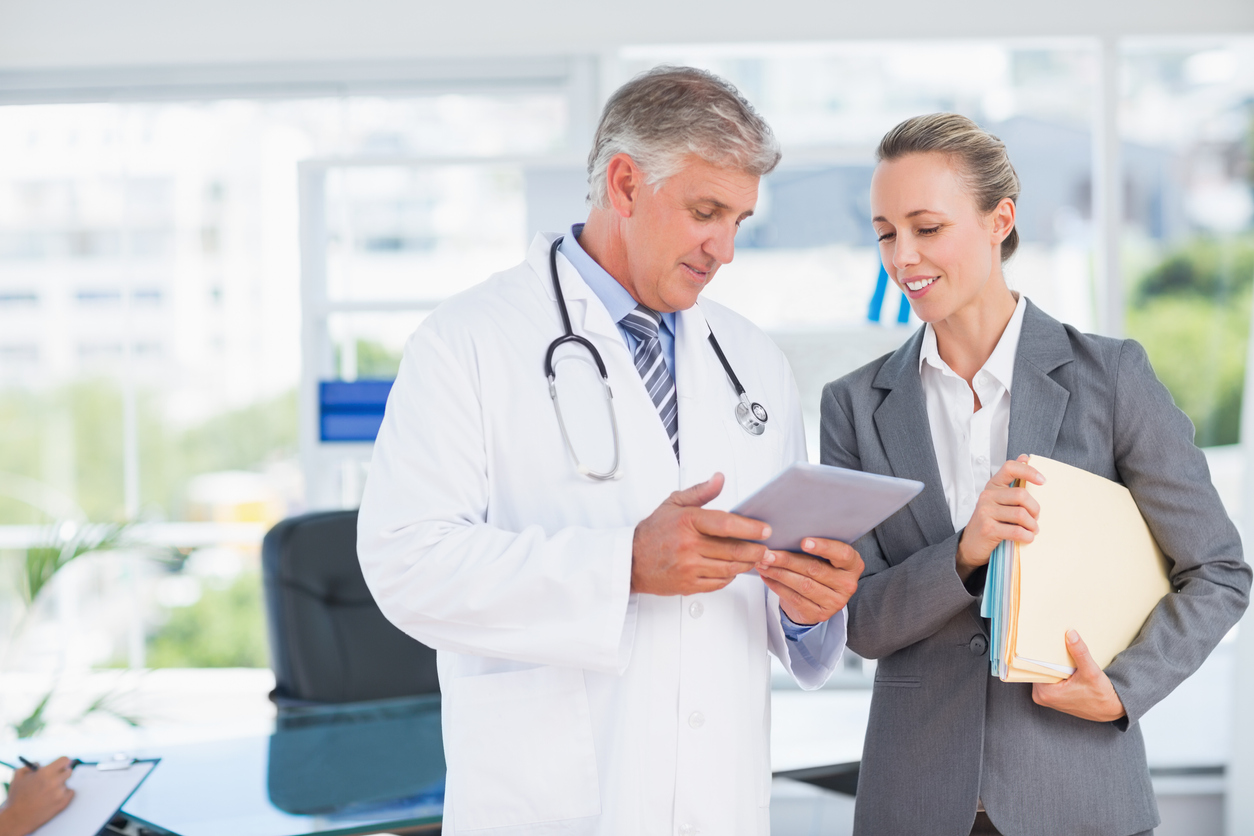 Confident doctor and pretty businesswoman discussing in medical office