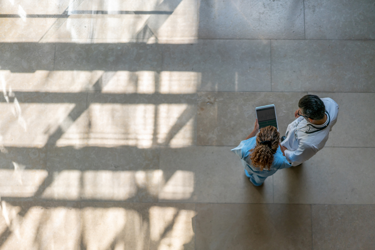High angle view - female nurse showing something to doctor on tablet at the hospital 