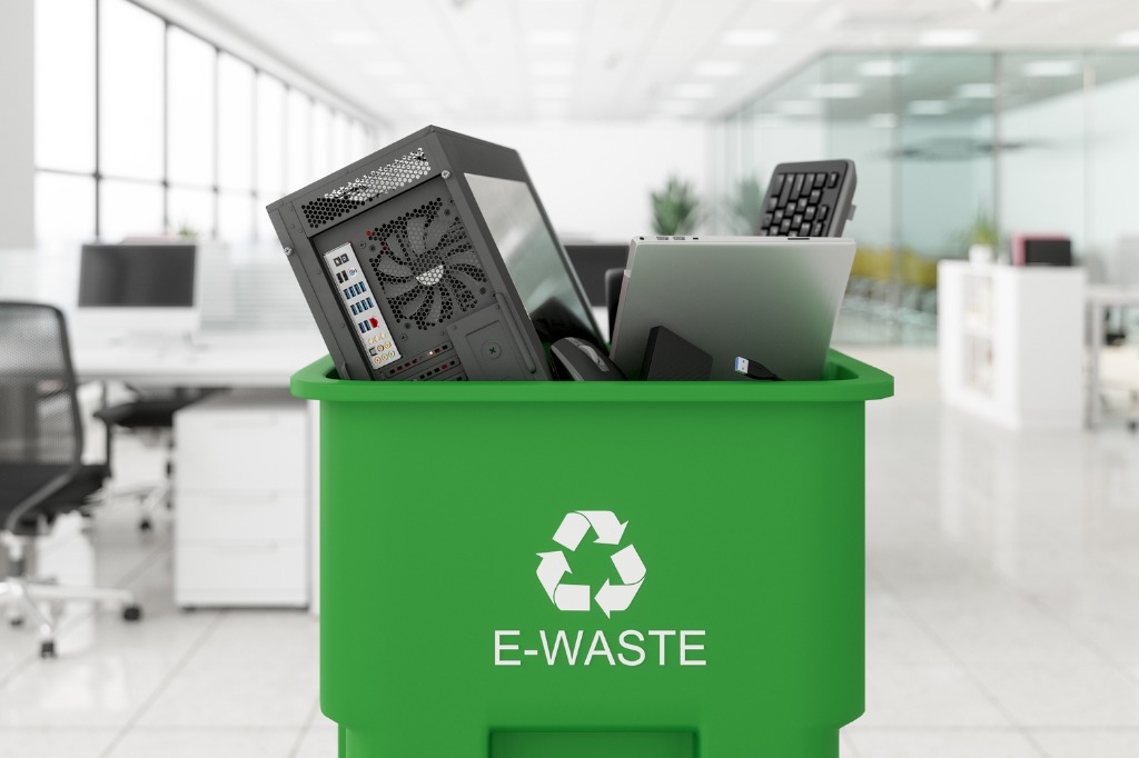 Electronic wastes collected in the green colored garbage bin with e-waste symbol on it in the office