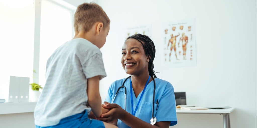 Pediatrician smiling at young patient